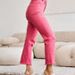 Model wearing pink Crop Dylan Full Size Tummy Control High Waist Raw Hem Jeans with white heels.