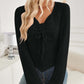 Woman wearing Bella Road ribbed drawstring long sleeve black T-shirt with jeans in a cozy room.