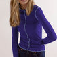 Model wearing a Basic Bae Contrast Trim Mock Neck Long Sleeve T-Shirt in purple with blue trim, styled with jeans.