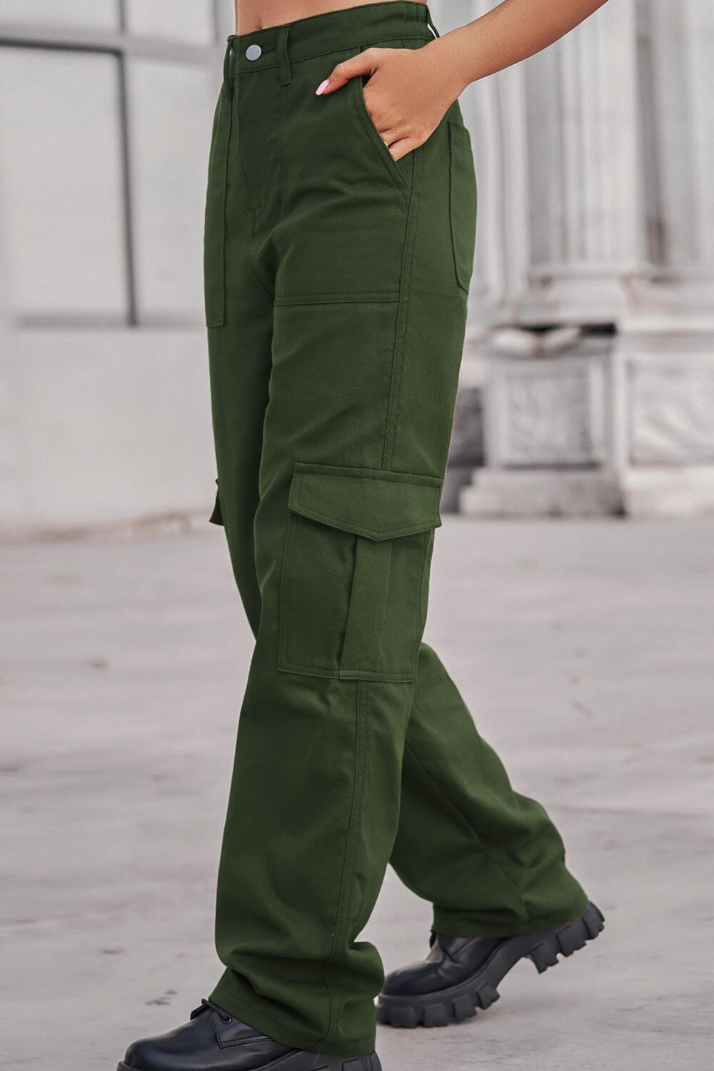 Woman wearing Baeful Long Straight Leg Jeans with pockets in green, standing outdoors.