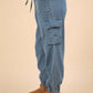 Side view of Washed Drawstring Jogger Cargo Jeans with elastic waist, side pockets, and raw detail, showcasing casual trendy style.