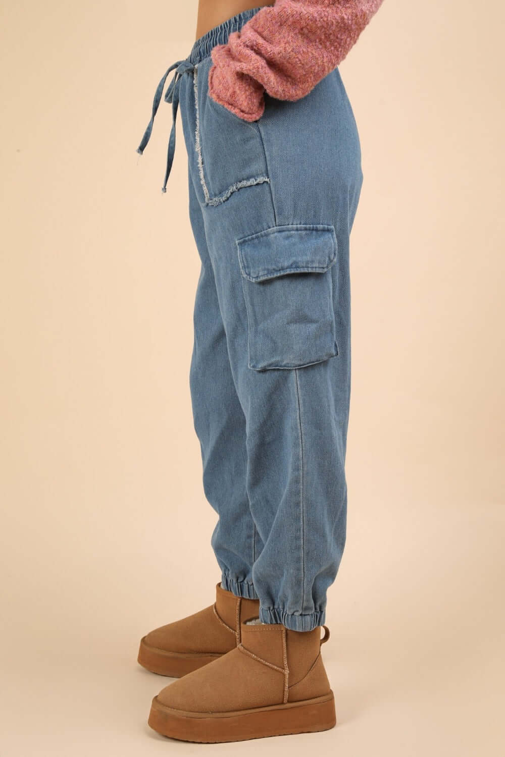 Side view of Washed Drawstring Jogger Cargo Jeans with elastic waist, side pockets, and raw detail, showcasing casual trendy style.