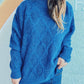 Woman wearing Bella Road Diamond Round Neck Long Sleeve Sweater in blue with jeans