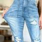 Woman wearing Judy Blue distressed straight jeans with high waist and patch pockets, highlighting trendy ripped details and flattering silhouette.