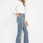 Stylish woman in Judy Blue tummy control bootcut jeans with embroidered pockets, showcasing a trendy and flattering fit.