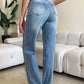 Woman wearing Judy Blue high waist wide leg jeans showcasing back view in a modern living room