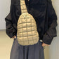 A stylish quilted nylon crossbody bag in beige paired with a black shirt and gray skirt, showcasing modern fashion elegance.