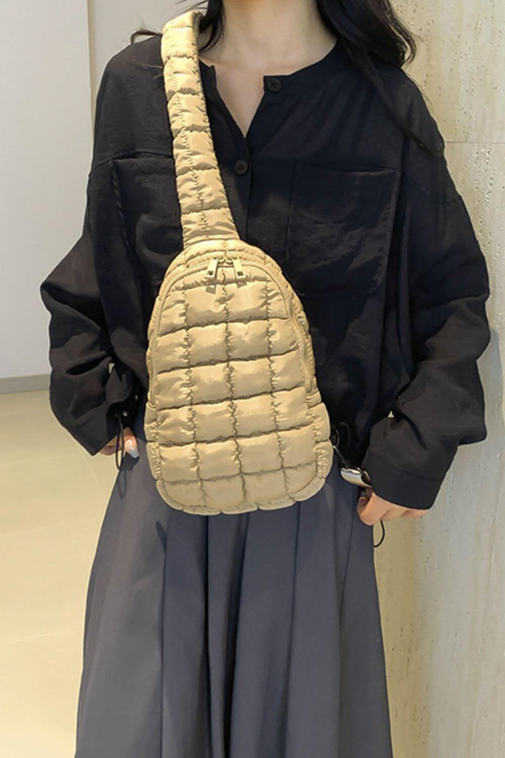 A stylish quilted nylon crossbody bag in beige paired with a black shirt and gray skirt, showcasing modern fashion elegance.