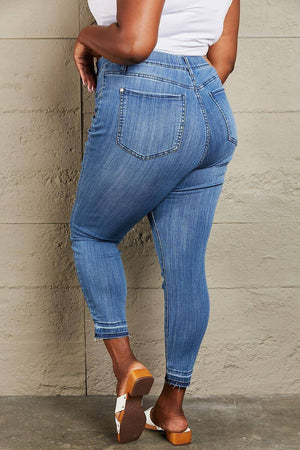 Woman wearing Janavie full-size high waisted pull-on skinny jeans with release hem back view. Judy Blue Jeans.