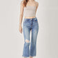 Fashion model wearing high waist distressed cropped bootcut Risen Jeans, showcasing contemporary style with a flattering, edgy look.