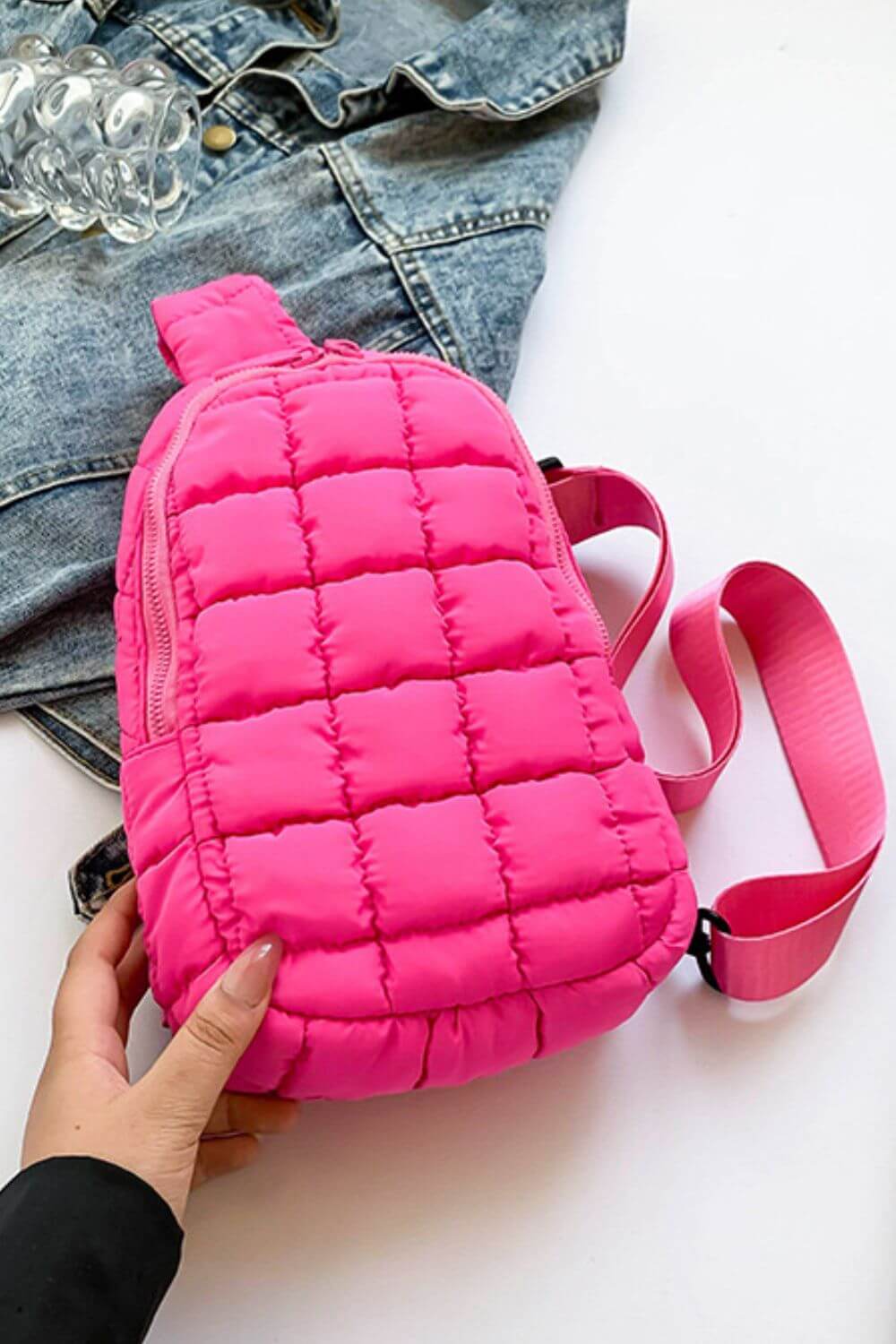 Vibrant pink Bella Road Quilted Nylon Crossbody Bag on denim jacket, perfect for stylish adventures and trendsetting looks.