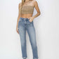 High Waist Distressed Cropped Risen Jeans on model with tan tube top and clear heels, showcasing trendy and edgy look against white backdrop