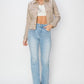 Plus size model wearing a trendy cropped denim jacket with light blue jeans and stylish heels.