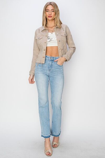 Plus size model wearing a trendy cropped denim jacket with light blue jeans and stylish heels.