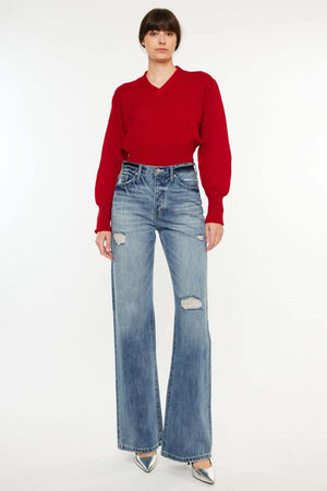 Trendy distressed high waist bootcut jeans paired with a red sweater and silver heels for a chic retro look. Perfect for casual and elegant wear.