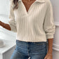 Woman wearing a white ribbed Johnny collar long sleeve t-shirt with blue jeans, holding a coffee cup.