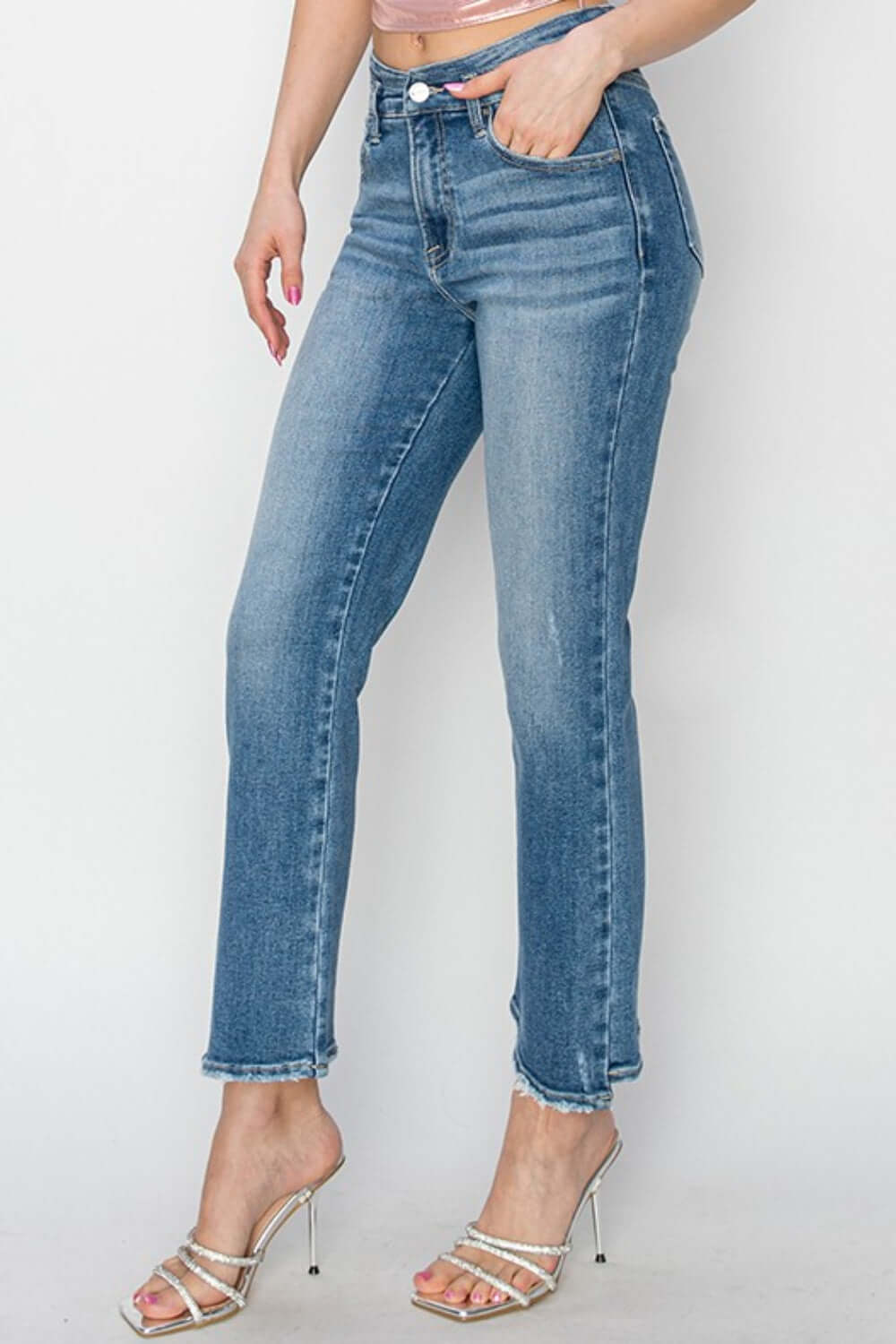 Woman wearing high rise slim straight jeans from Risen Jeans, showcasing a flattering fit and classic denim style with heels.