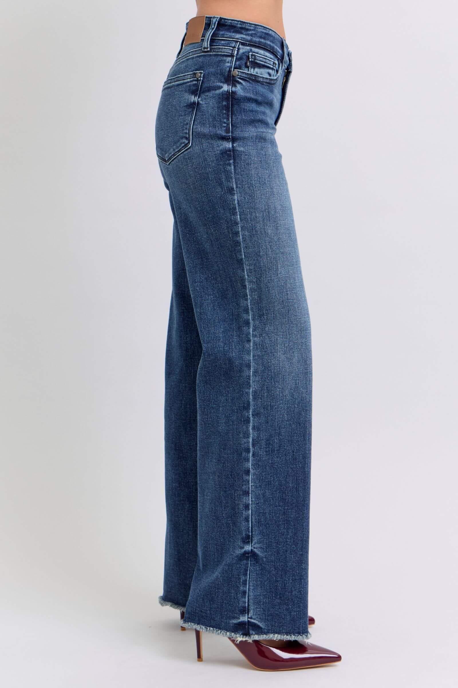 Side view of Judy Blue mid-rise jeans with raw hem, showcasing a stylish and casual denim look.