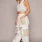 Stylish model in distressed white jeans with crochet patches, paired with a matching crop top and trendy sneakers.