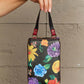 Hand holding Nicole Lee USA small crossbody wallet with colorful floral pattern, featuring removable strap and multiple compartments.