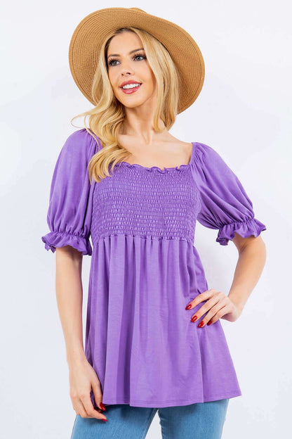 Woman wearing purple ruffled short sleeve smocked blouse with hat