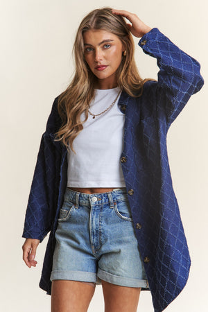 Woman wearing J.NNA rhombus stitched button-up denim shacket over a white tee and denim shorts.