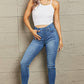 Woman wearing Janavie full size high waisted pull on skinny jeans with release hem detailing from Judy Blue Jeans.