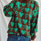 Woman wearing Bella Road Heart Contrast Long Sleeve Dropped Shoulder Sweater with green hearts and jeans.