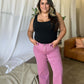 Woman wearing RFM Full Size High Rise Garment Dye Wide Leg Jeans in pink, standing with hands in pockets, casual chic style.