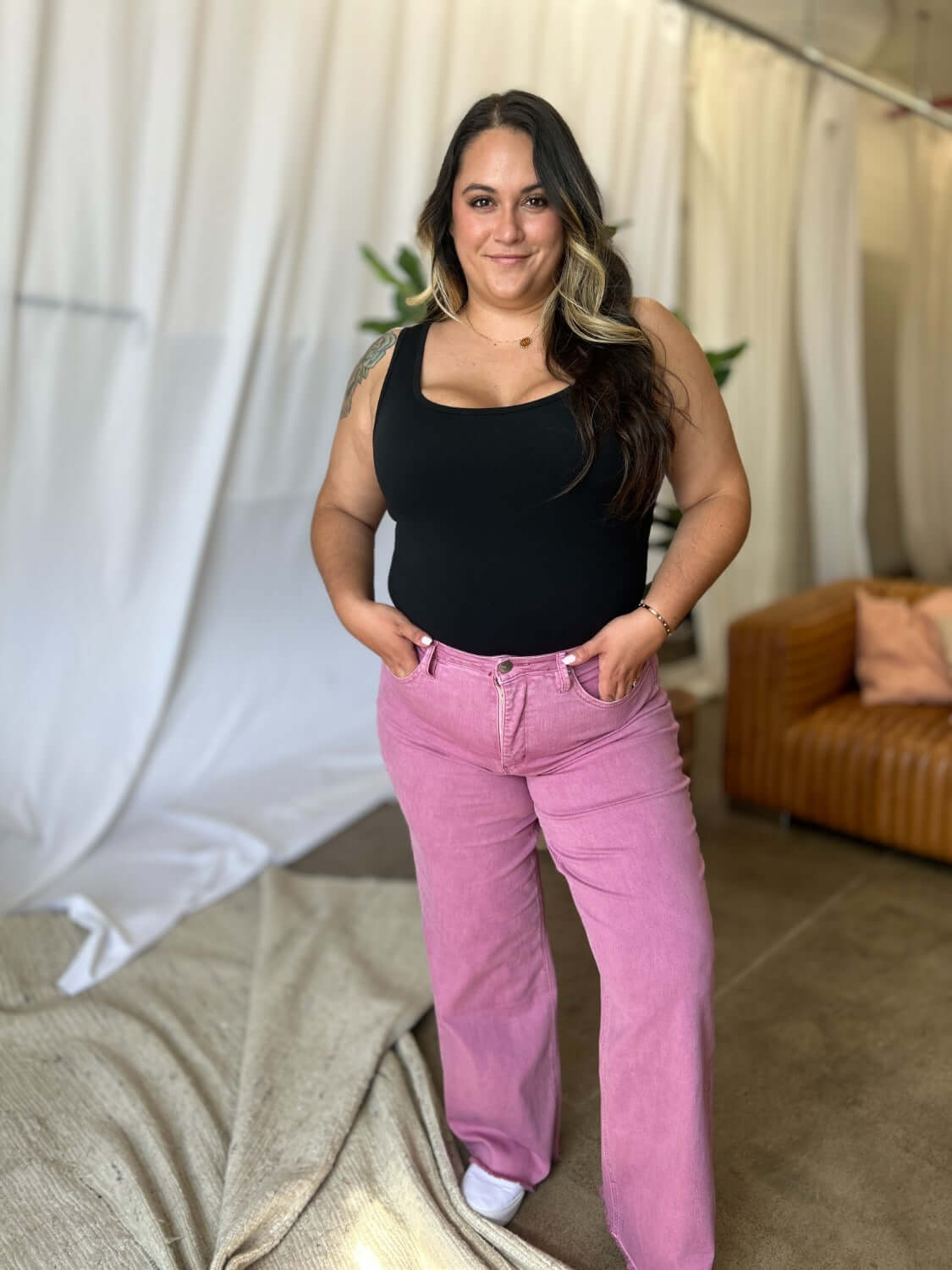 Woman wearing RFM Full Size High Rise Garment Dye Wide Leg Jeans in pink, standing with hands in pockets, casual chic style.