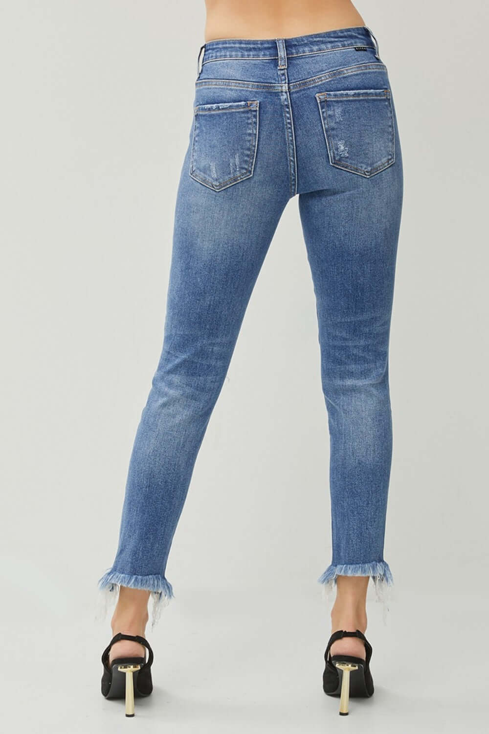 Back view of Risen Jeans Distressed Frayed Hem Slim Jeans, showcasing trendy distressed detailing and frayed hem, perfect for a chic, edgy look.