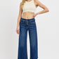 Model showcasing RISEN wide leg jeans with raw hem and buckle details, paired with a trendy crop top.