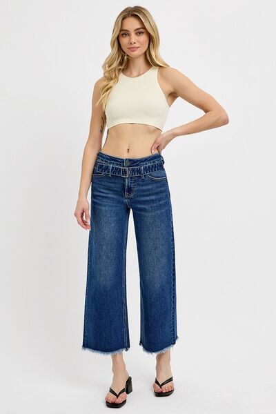 Model showcasing RISEN wide leg jeans with raw hem and buckle details, paired with a trendy crop top.