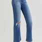 Risen distressed high rise crop flare jeans with ripped knee, paired with white sneakers for an edgy and casual look.