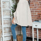 Woman wearing Bella Road Round Neck Batwing Sleeve Sweater, posing indoors with casual jeans and sneakers for a stylish look.