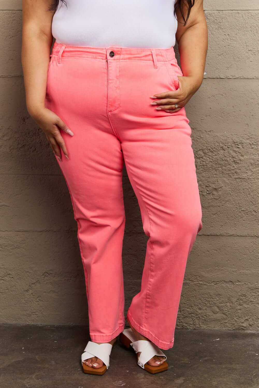 Woman wearing Kenya High Waist Side Twill Straight Jeans in bright coral, showcasing the flattering fit and elegant side twill detailing.