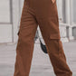 Woman wearing Baeful Long Straight Leg Jeans with Pockets in brown, standing outdoors and showcasing chic and comfortable fashion.