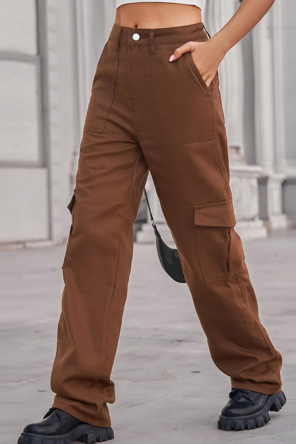 Woman wearing Baeful Long Straight Leg Jeans with Pockets in brown, standing outdoors and showcasing chic and comfortable fashion.