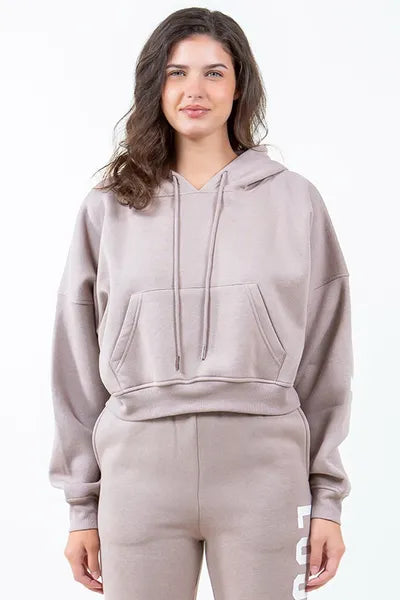 Trendy American Bazi 'Los Angeles' cropped hoodie in soft beige, featuring a drawstring detail and front pocket.