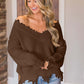 Woman wearing Bella Road Frayed Hem Dropped Shoulder Sweater in a cozy living room setting.