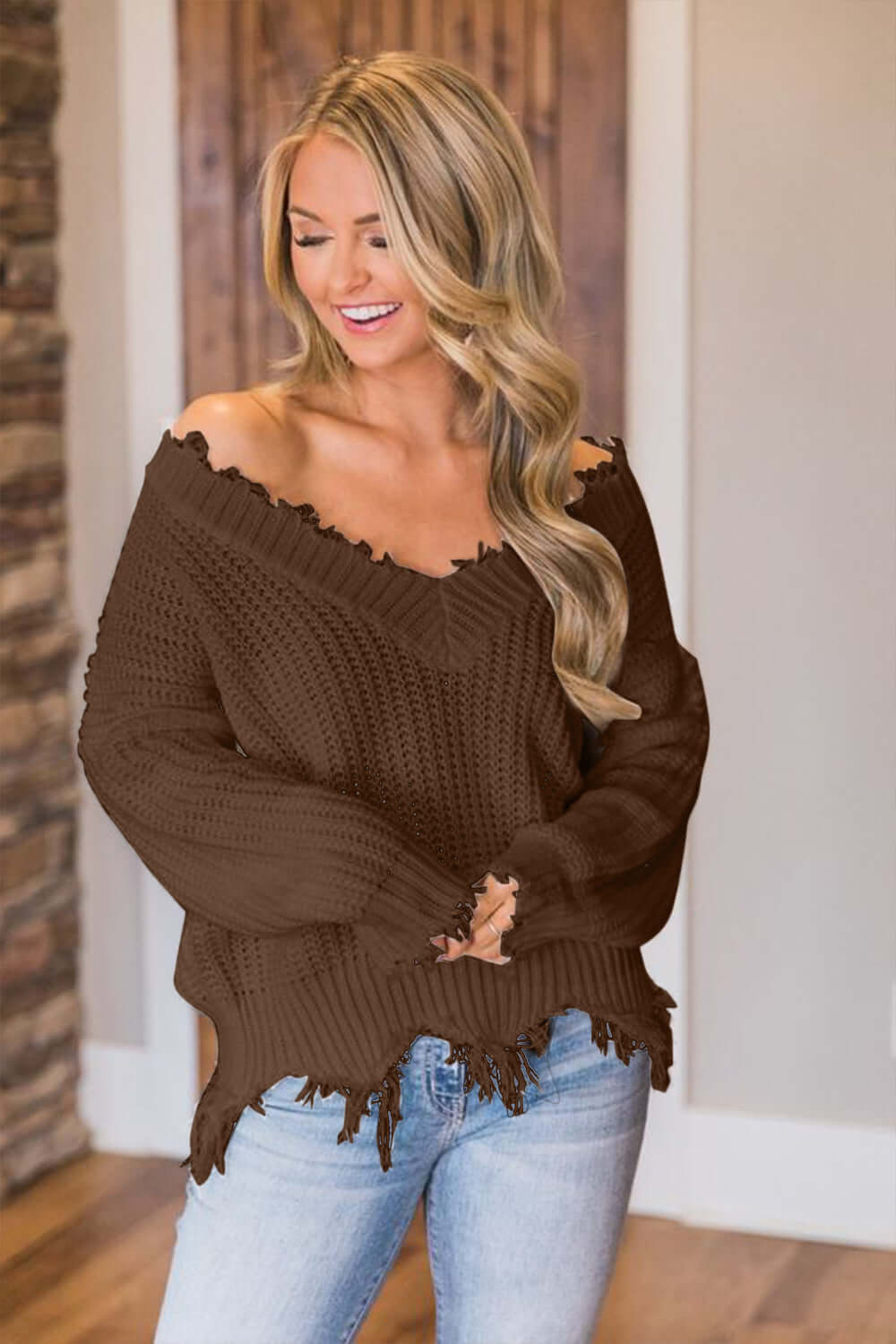 Woman wearing Bella Road Frayed Hem Dropped Shoulder Sweater in a cozy living room setting.