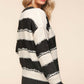 Woman wearing Haptics Striped Contrast Distressed Sweater, showcasing trendy style with black and white stripes and distressed details.