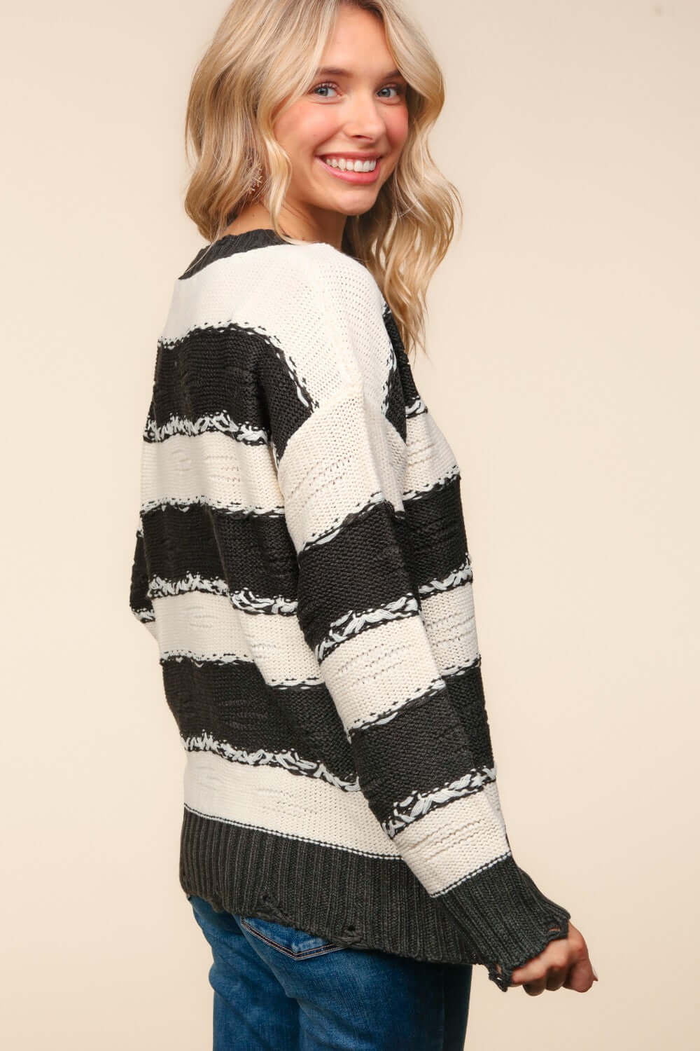 Woman wearing Haptics Striped Contrast Distressed Sweater, showcasing trendy style with black and white stripes and distressed details.