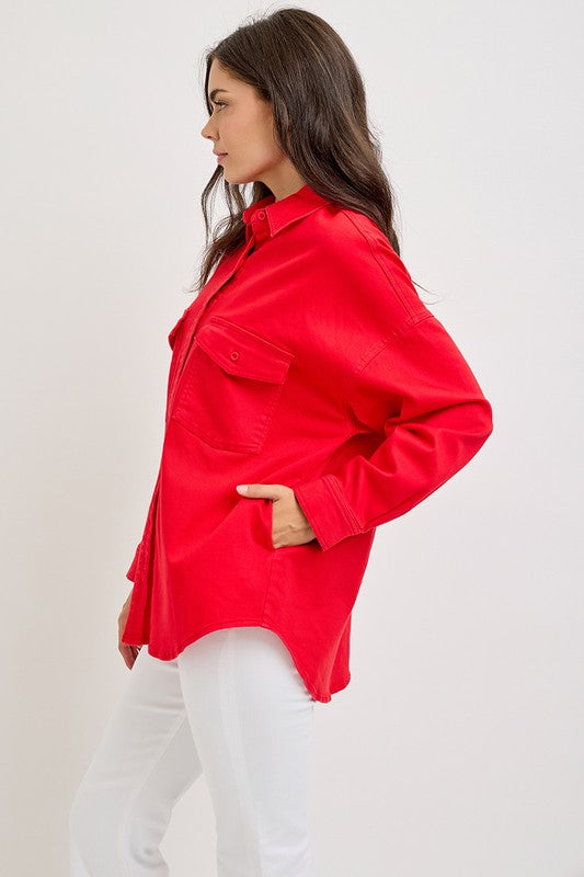 Stylish woman in a red button-down long sleeve denim shacket with chest pockets, paired with white pants.