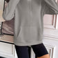 Ivy Lane Half Zip Raglan Sleeve Pocketed Sweatshirt in grey with black shorts, front view in indoor setting