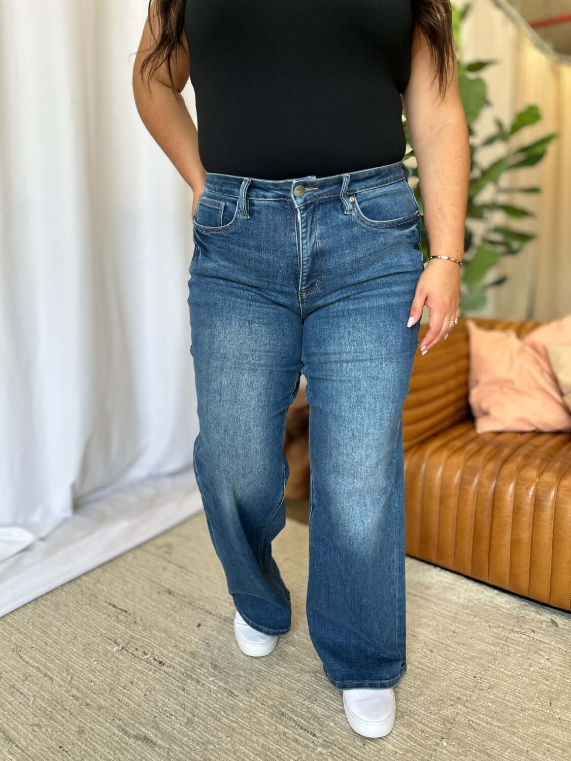 Woman wearing RFM Full Size High Rise Tummy Control Wide Leg Jeans in a casual indoor setting