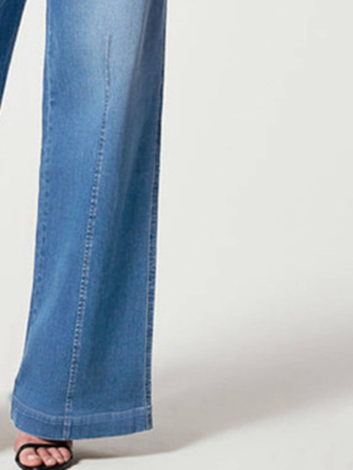 Close-up of wide leg long jeans in solid blue with a chic style, moderate stretch, and full-length design, featuring 75% cotton and 22% polyester.