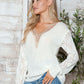 Woman wearing Bella Road openwork V-neck long sleeve sweater in cozy, stylish design.