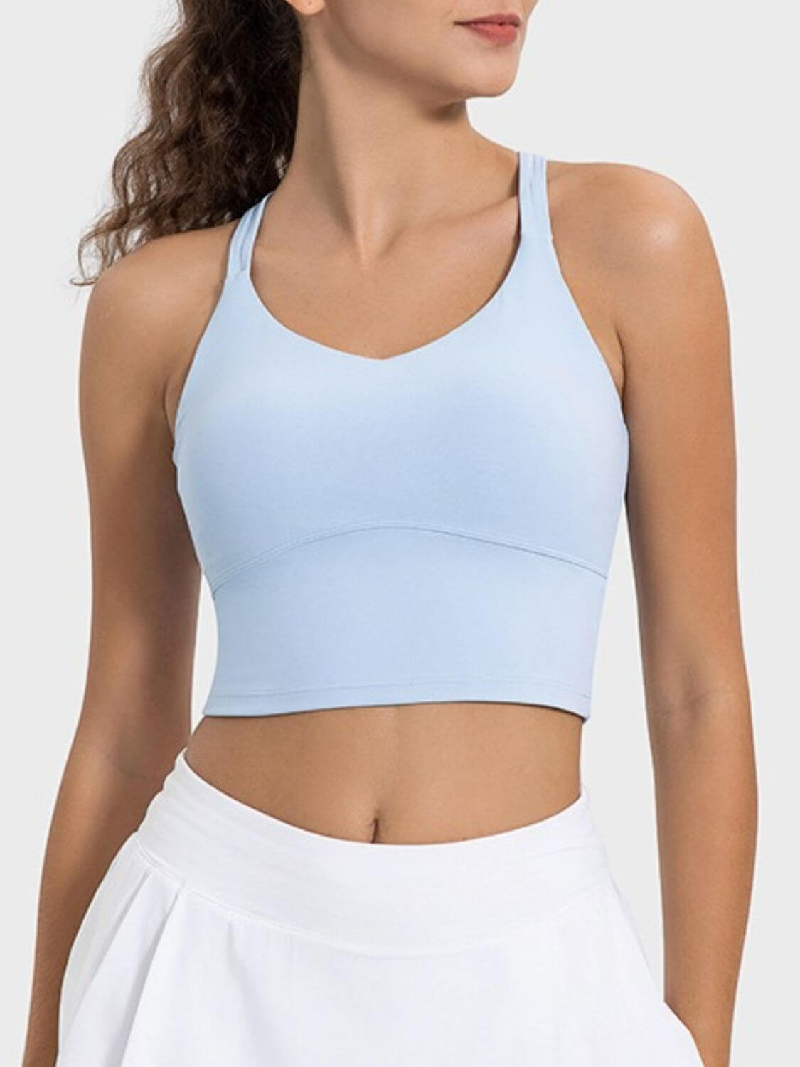 Light blue crisscross tank top, perfect for your active lifestyle, featuring a stylish round neck and moderate stretch.