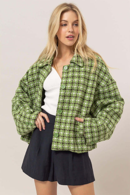 Stylish woman in a green tweed plaid button-up collared jacket over a white top and navy shorts. Perfect for any season!